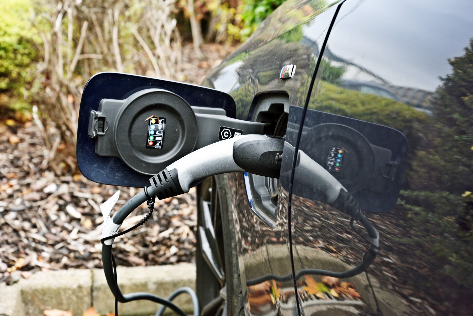 A close-up of a charging cable sticking out of an electric car