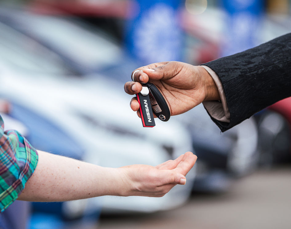 A car dealer handing car keys to a new Motability Scheme customer