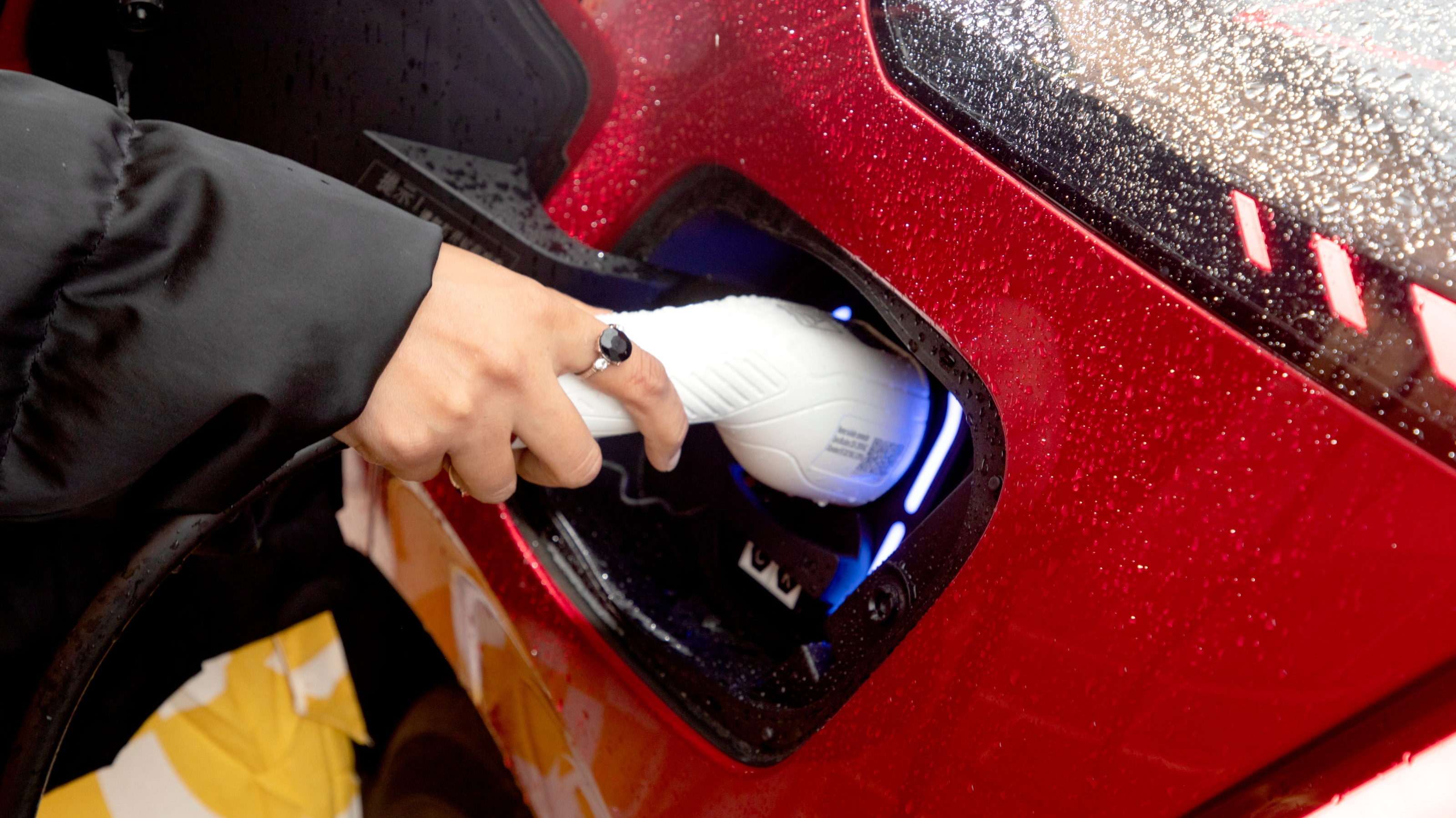 Motability Scheme customers hand charging electric car