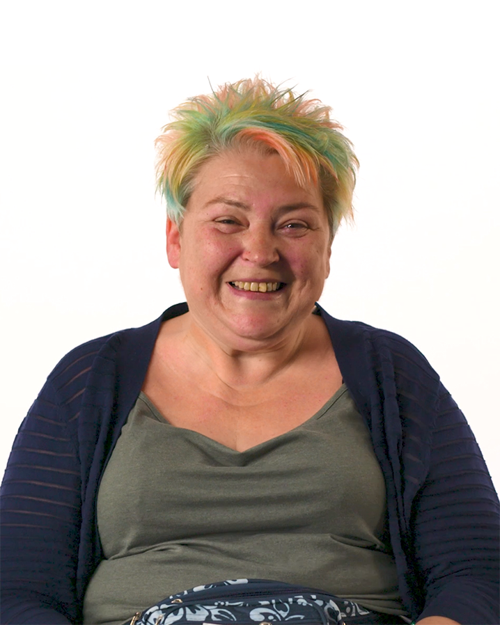 A woman with short, colourful hair smiling