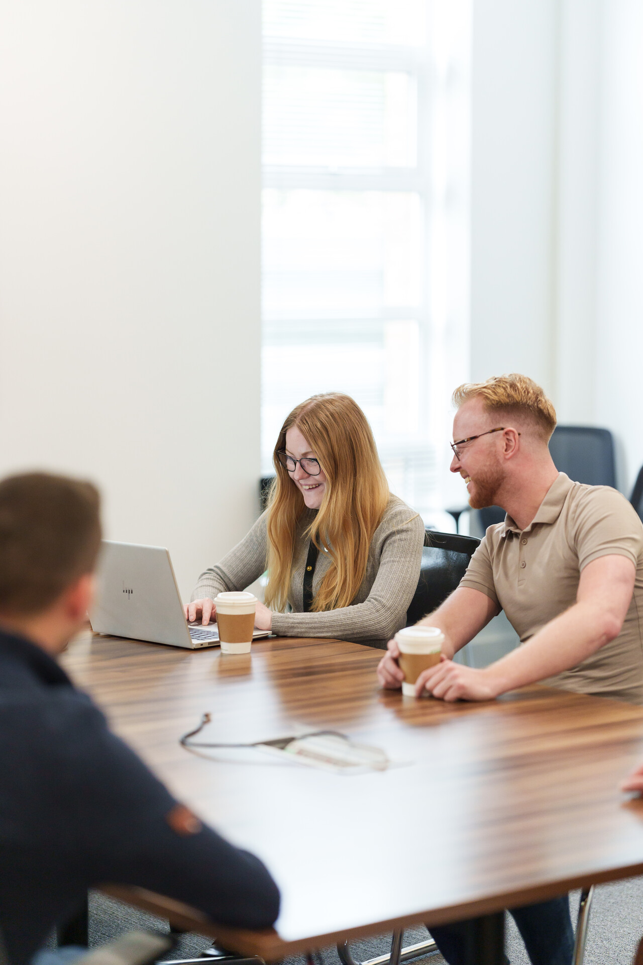 A smiling woman and man look at something together on a laptop